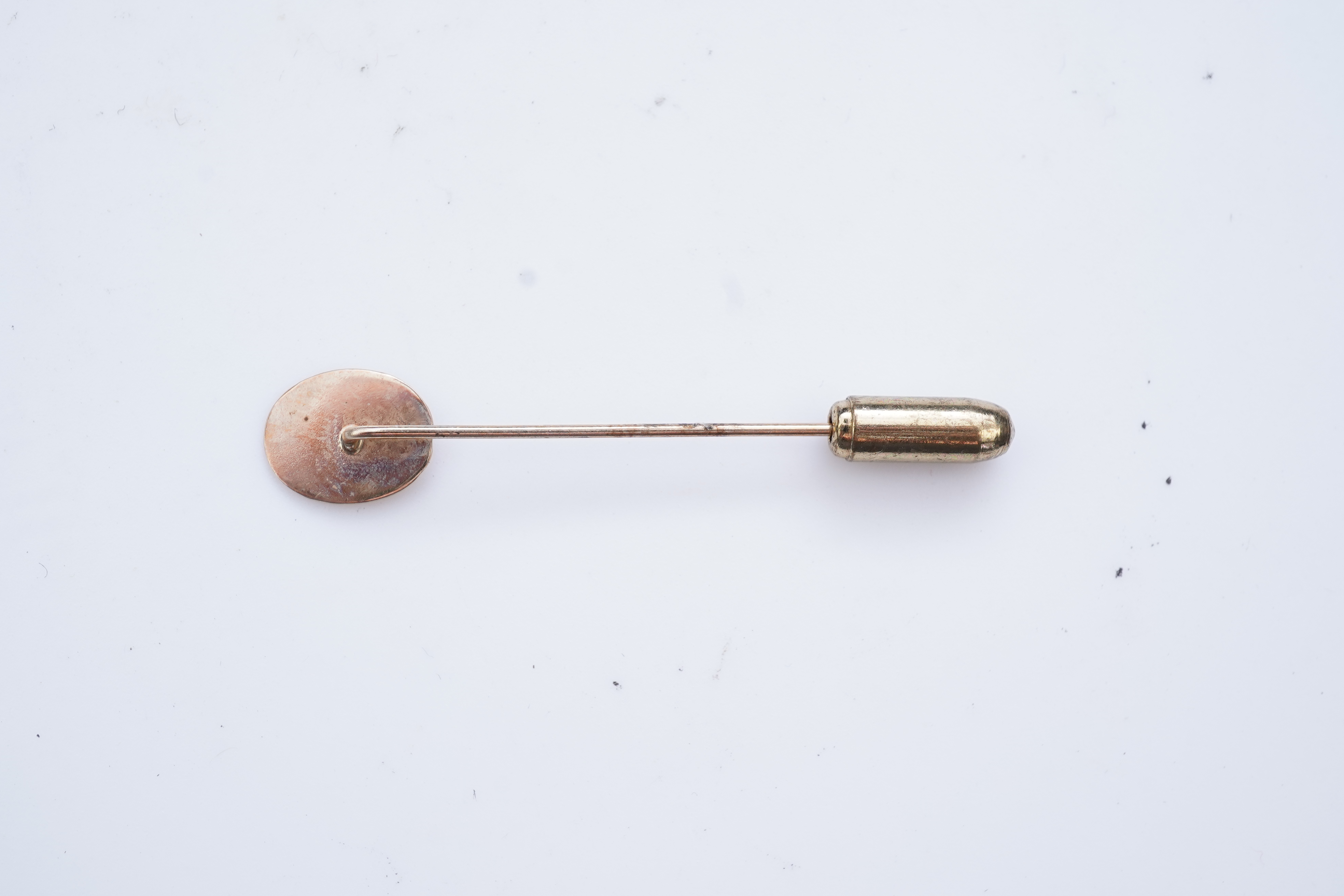 A collection of six stick pins, comprising: three gold stick pins, one set with a hardstone cameo, Austrian assay marks; a gold stick pin with a faceted edge; and a gold stick pin of Masonic design, stamped 9CT, combined